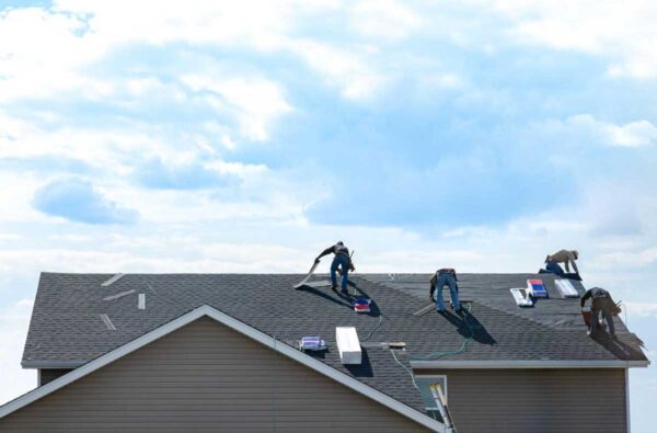 Four workers replacing a roof